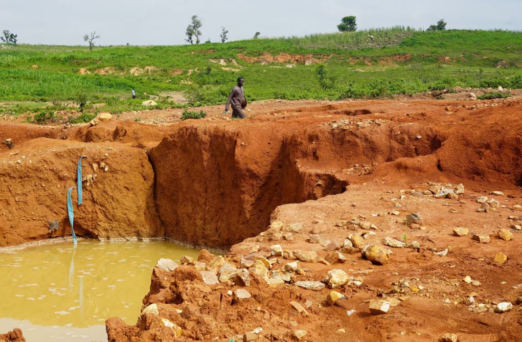 Adamu Isah, 22, a survivor, walks near an illegal mining site close to the M.I. Wushishi Housing Estate in Niger State, Nigeria on September 19, 2026.
